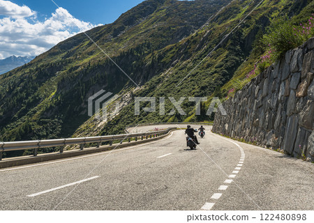 Two bikers riding on the winding Grimsel Pass road in the Swiss Alps, Canton Valais, Switzerland 122480898