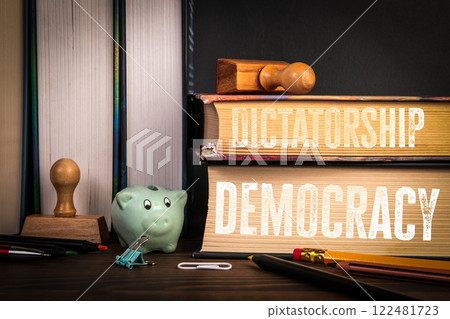 DEMOCRACY and DICTATORSHIP. Stack of books on a wooden shelf 122481723