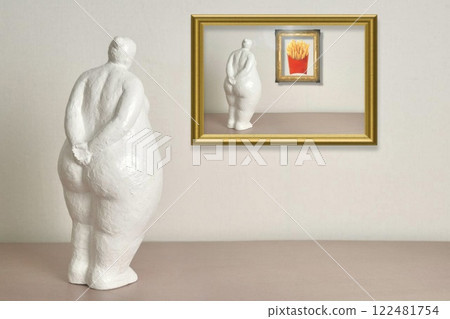 A white sculpture of a curvy figure gazes at a framed picture of French fries, blending humor with social commentary on beauty standards and desire. A white sculpture of a curvy figure gazes at a framed picture of French fries, blending humor with social commentary on beauty standards and desire. 122481754