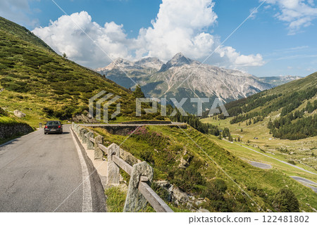 A car drives on the Spluegen pass road in the Swiss Alps, Canton of Grisons, Switzerland A car drives on the Spluegen pass road in the Swiss Alps, Canton of Grisons, Switzerland 122481802