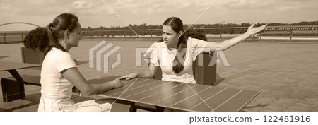Girls arguing in a cafe Girls arguing in a cafe 122481916