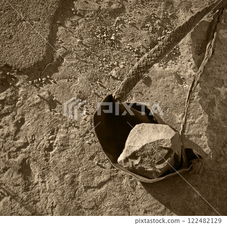 An antique leather sling lies on the ground 122482129