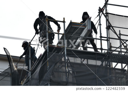 Apartment renovation work: Scaffolding workers dismantling temporary scaffolding Apartment renovation work: Scaffolding workers dismantling temporary scaffolding 122482339