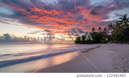 Stunning Tropical Sea Beach Sunset with Vibrant Clouds and Calm Waters. 122482487