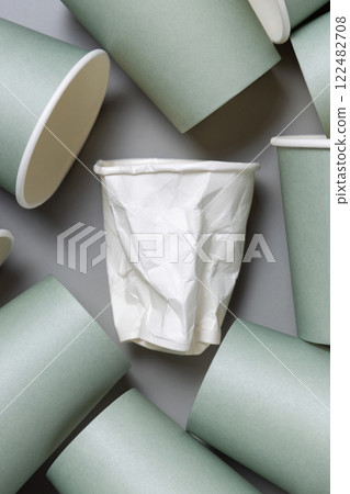 New light green paper cups and crumpled used white one on a gray top view, mockup New light green paper cups and crumpled used white one on a gray top view, mockup 122482708