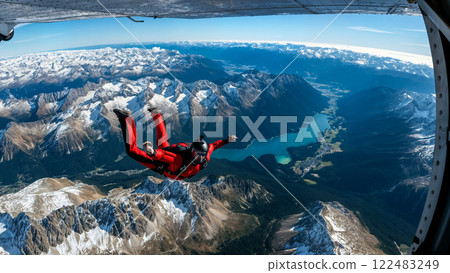 Skydiver in Red Suit Jumping from a Plane Over Snowy Mountains. 122483249