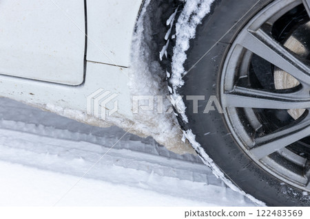 Snow clumps stuck to the wheel well 122483569