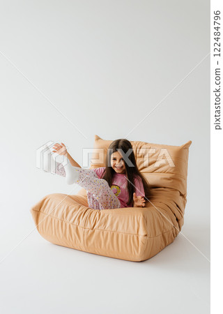 Happy girl having fun on brown sofa at studio 122484796
