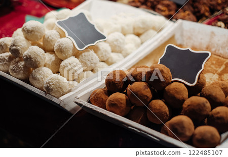 Two trays of chocolate and white desserts sit side by side 122485107
