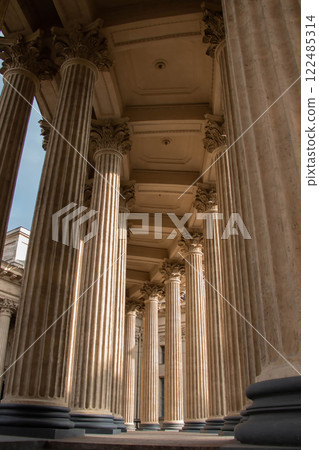 Symmetrical Vertical view Ancient Greek Stone Corinthian Fluted Columns showcasing Architecture Kazan Cathedral St Petersburg. Sunlight breaks through Colonnade forming laconic shadows on the flutes Symmetrical Vertical view Ancient Greek Stone Corinthian Fluted Columns showcasing Architecture Kazan Cathedral St Petersburg. Sunlight breaks through Colonnade forming laconic shadows on the flutes 122485314