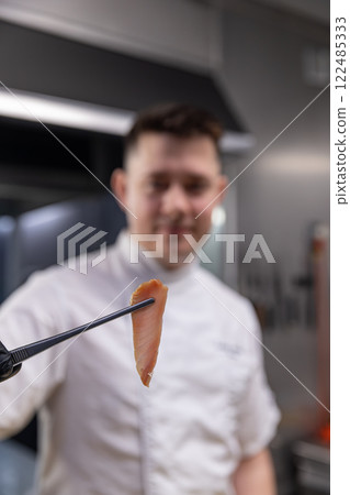 Chef showing a perfect slice of smoked fish 122485333