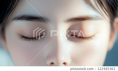 Front view of an Asian female model with her eyes closed. Beauty portrait with beautiful skin and natural make-up. Front view of an Asian female model with her eyes closed. Beauty portrait with beautiful skin and natural make-up. 122485361