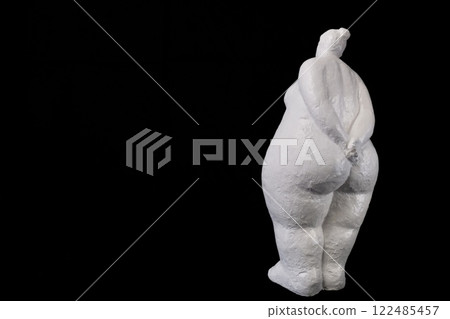 White Plaster Lady Standing Back on Black Solid Background with Copy Space 122485457