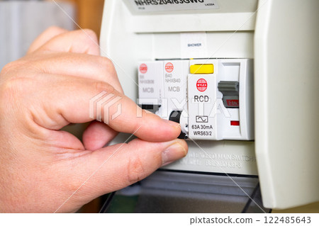 Electric power meter, a man's hand turning off the electricity due to increasing price for electricity bills Electric power meter, a man's hand turning off the electricity due to increasing price for electricity bills 122485643