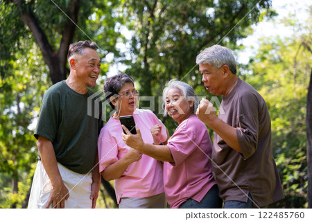 Group of happy Senior Retirement Using Smartphone and laughing outdoors at the park after a workout and spending time together, concepts about the elderly, seniority, and wellness aging Group of happy Senior Retirement Using Smartphone and laughing outdoors at the park after a workout and spending time together, concepts about the elderly, seniority, and wellness aging 122485760