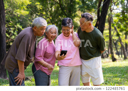 Group of happy Senior Retirement Using Smartphone and laughing outdoors at the park after a workout and spending time together, concepts about the elderly, seniority, and wellness aging Group of happy Senior Retirement Using Smartphone and laughing outdoors at the park after a workout and spending time together, concepts about the elderly, seniority, and wellness aging 122485761