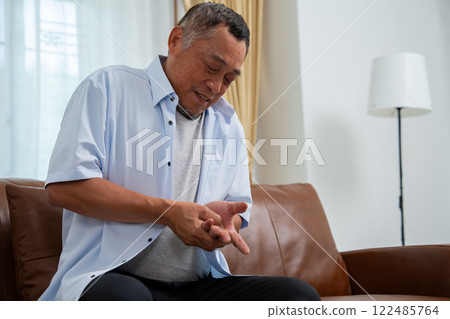 Elderly Asian male patients suffer from numbing pain in hands from rheumatoid arthritis. Senior men massage his hand with wrist pain. Concept of joint pain, rheumatoid arthritis, and hand problems. Elderly Asian male patients suffer from numbing pain in hands from rheumatoid arthritis. Senior men massage his hand with wrist pain. Concept of joint pain, rheumatoid arthritis, and hand problems. 122485764