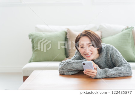 A woman in winter clothes using a smartphone A woman in winter clothes using a smartphone 122485877