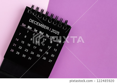 December black desk calendar for 2025 year on purple background. 122485920
