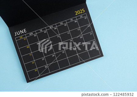 June 2025 Black calendar opening on blue background. June 2025 Black calendar opening on blue background. 122485932