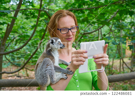woman taking photo selfie with ring tailed lemur 122486081