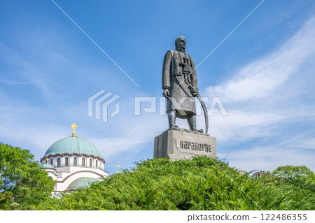 The Karadorde Monument stands proudly near Saint Sava Cathedral in Belgrade, Serbia, surrounded by lush greenery and set against a bright blue sky. The Karadorde Monument stands proudly near Saint Sava Cathedral in Belgrade, Serbia, surrounded by lush greenery and set against a bright blue sky. 122486355