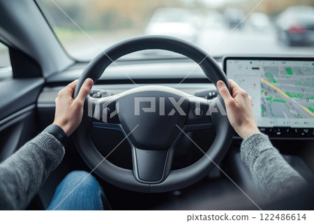 A person is driving a car with a steering wheel and a GPS device 122486614