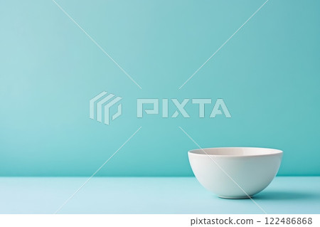 Minimalist Studio Shot of a Smooth Solid White Bowl on a Turquoise Background 122486868