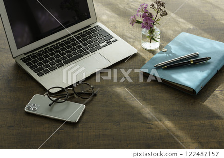 Image of business at home: laptop computer on desk, smartphone, notebook and pen, glasses 122487157