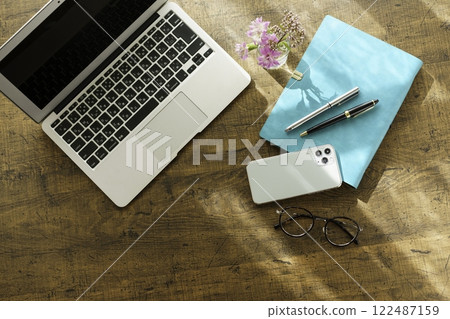 Image of business at home: laptop on desk, smartphone, notebook and pen, glasses, bird's-eye view 122487159