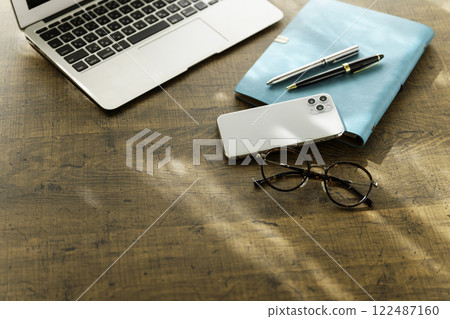家庭辦公室的形象:桌上的筆記型電腦、智慧型手機、筆記本和筆、眼鏡 家庭辦公室的形象:桌上的筆記型電腦、智慧型手機、筆記本和筆、眼鏡 122487160