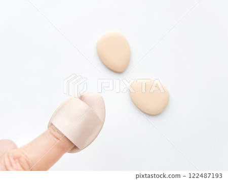 A makeup puff that you wear on your finger 122487193