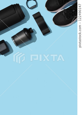 Sports background with mat, fitness rubber band, strap, sneakers, hand grips on blue background. Fitness items, healthy lifestyle concept. Space for your text 122490147
