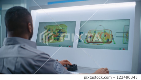 Security Officer Controls Luggage Screening on Computer Monitors Using Modern Software 122490343