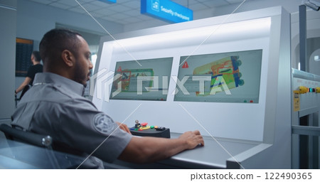 Security Officer Monitors Baggage Screening on Computer Screens, Finds Suspicious Object Security Officer Monitors Baggage Screening on Computer Screens, Finds Suspicious Object 122490365