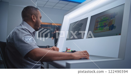 Airport Security Checkpoint: Security Officer Monitors Baggage Screening on Computer Screens 122490394
