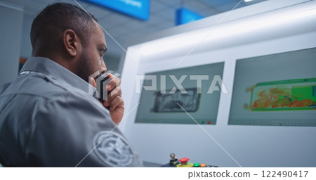 Security Officer Monitors Baggage Screening on Computer, Finds Suspicious Object, Talks by Walkie-Talkie Security Officer Monitors Baggage Screening on Computer, Finds Suspicious Object, Talks by Walkie-Talkie 122490417