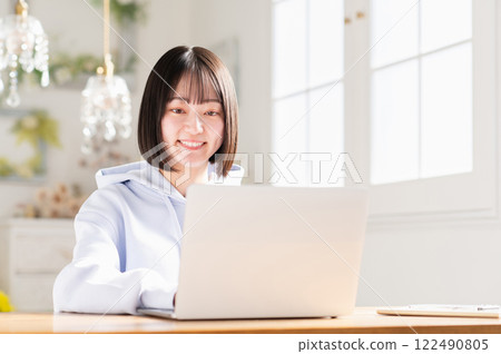 A young woman using a laptop in the living room A young woman using a laptop in the living room 122490805