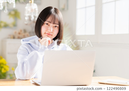 A young woman using a laptop in the living room 122490809