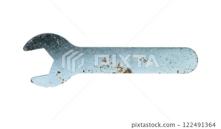 A vintage metal wrench is resting horizontally on a white surface 122491364