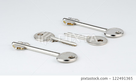 Four metal keys displayed on a plain white surface showcase their unique designs 122491365