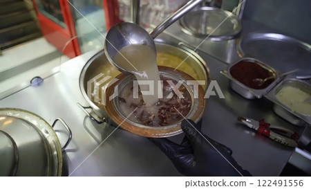 Expertly Pouring Flavorful Broth into a Traditional Bowl of Turkish Kelle Paca Expertly Pouring Flavorful Broth into a Traditional Bowl of Turkish Kelle Paca 122491556