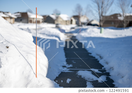 Sidewalk with edge markers used for snow blowing guides Sidewalk with edge markers used for snow blowing guides 122491591