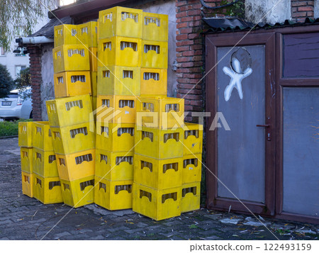 Boxes with empty glass bottles. Bottles in yellow boxes in the backyard of a restaurant.  The concept of collecting used bottles. 122493159