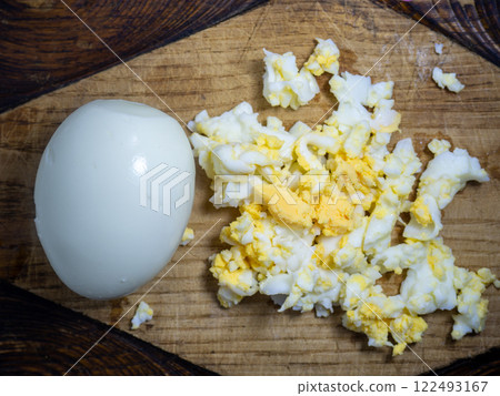 Grated egg. Protein. protein product. Salad preparation. Grated boiled egg on a kitchen board. Grated egg. Protein. protein product. Salad preparation. Grated boiled egg on a kitchen board. 122493167