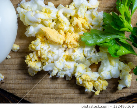 Grated egg. Protein. protein product. Salad preparation. Grated boiled egg on a kitchen board. Grated egg. Protein. protein product. Salad preparation. Grated boiled egg on a kitchen board. 122493169