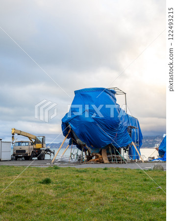 large yacht is covered with a tarpaulin. The ship is under repair. large yacht is covered with a tarpaulin. The ship is under repair. 122493215