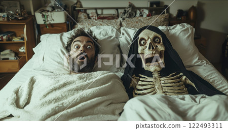 Surprised bearded man in bed with skeleton companion in hooded cloak, expressive nighttime scene in cozy bedroom setting 122493311