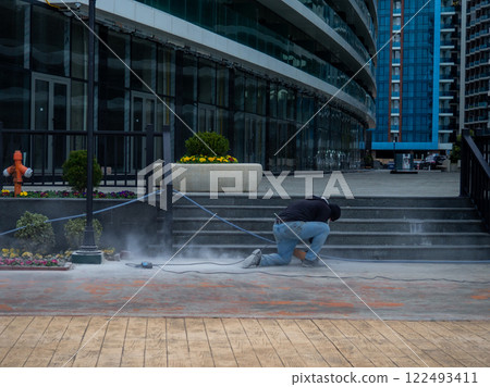workers are working. Hard work. A man polishes steps with a grinder. workers are working. Hard work. A man polishes steps with a grinder. 122493411