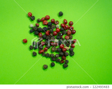 Peppercorns on a green background. Red, white and black peppercorns. concept of natural cuisine. Seasoning for dishes. The concept of spicy food. Spicy condiment. Cooking. Peppercorns on a green background. Red, white and black peppercorns. concept of natural cuisine. Seasoning for dishes. The concept of spicy food. Spicy condiment. Cooking. 122493483